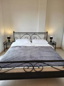 - un lit avec un cadre noir, des draps blancs et des oreillers dans l'établissement Villa am Meer mit fantastischen Panoramablick, 