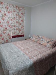 1 dormitorio con 1 cama con flores en la pared en Hermoso departamento nuevo en Pucon equipado con 3 dormitorios wifi y estacionamiento privado a 5 minutos del centro y lago, en Pucón
