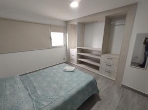 Un dormitorio con una cama con una manta azul. en ALMAR FONTANA en Comodoro Rivadavia