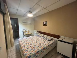 Travessa 12 - Suítes centro de Serra Negra - SP في سيرا نيجرا: غرفة نوم بسرير في غرفة