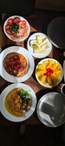 een tafel met witte borden met voedsel erop bij Tiny House Garden - Aparados da Serra - SC in Praia Grande