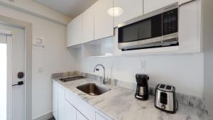 a white kitchen with a sink and a microwave at Park Royal Miami Beach in Miami Beach