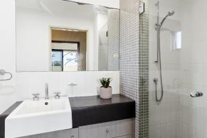 y baño blanco con lavabo y ducha. en Villa Sangiovese en Evans Head