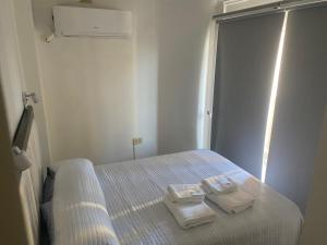 a bedroom with a bed with two towels on it at Departamento av.Cordoba in San Juan