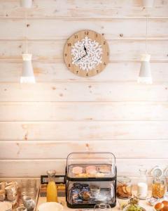 a clock on the wall above a table with food at Siedem Życzeń in Ustroń