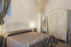 a bedroom with a bed and a dresser in it at Cà dei Palazzo - Guest House in Martina Franca