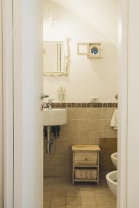 a bathroom with a sink and a toilet and a mirror at Cà dei Palazzo - Guest House in Martina Franca