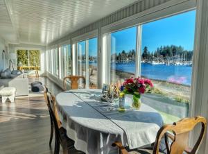 Bowser的住宿－The Beach House at Deep Bay，一间设有一张桌子并享有水景的用餐室