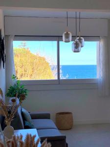 sala de estar con sofá azul y ventana grande en Superb apartment with sea view, 200m from beach en San-Martino-di-Lota