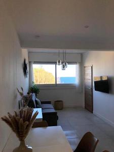 un soggiorno con tavolo e una grande finestra di Superb apartment with sea view, 200m from beach a San-Martino-di-Lota