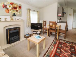 a living room with a fireplace and a table at Broad Down in Birtsmorton