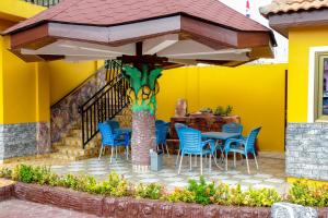 una mesa y sillas bajo una sombrilla en un patio en Hilton View Hotel, en Accra