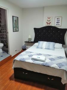 a bedroom with a bed with a blue and white quilt at Lopez House in Lima