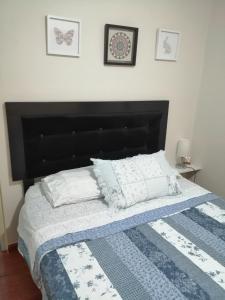 a bedroom with a bed with a blue and white quilt at Lopez House in Lima