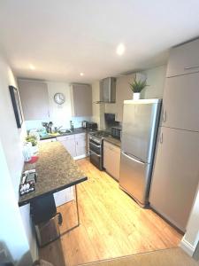 eine Küche mit einem Kühlschrank aus Edelstahl und Holzböden in der Unterkunft Lovely Central London Apartment in London