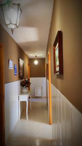 um corredor com uma escada com uma mesa e uma escada em Habitaciones CASA BRAIS em Barreiros