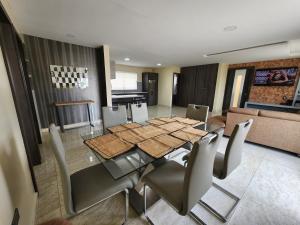 uma sala de jantar com uma mesa de vidro e cadeiras em Departamento amplio 2 dormitorios em Cuenca