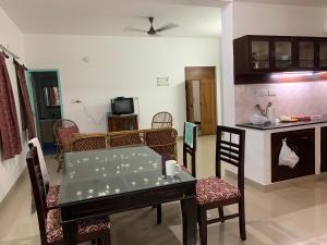 Una sala de estar con mesa y sillas y una cocina. en Peaceful_Pondy, en Pondicherry