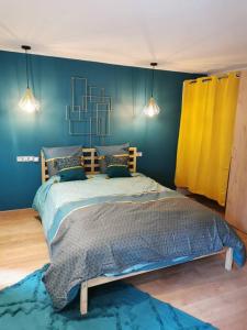 a bedroom with two beds with blue and yellow walls at Charmante Maison dans le Vieux Douai in Douai