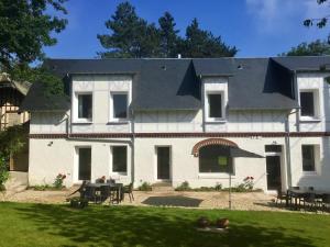 una gran casa blanca con techo negro en Villa Mathilde en Saint-Pierre-en-Port