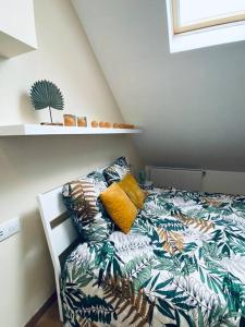 a bedroom with a bed with a tropical bedspread at Charmante Maison dans le Vieux Douai in Douai