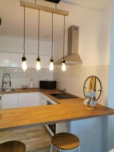 a kitchen with a wooden counter top and some lights at Charmante Maison dans le Vieux Douai in Douai