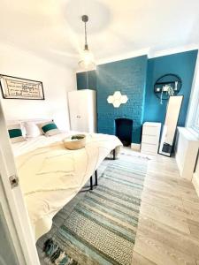 um quarto com uma cama e uma parede azul em Spacious Modern Victorian House in Rochester em Wainscot