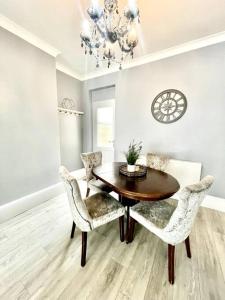 a dining room with a wooden table and chairs at Spacious Modern Victorian House in Rochester in Wainscot