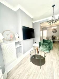 a living room with a green chair and a table at Spacious Modern Victorian House in Rochester in Wainscot