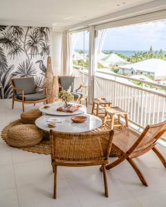 a living room with a table and chairs on a balcony at Appartement Toucan - Grand standing pleine vue mer in Saint-François