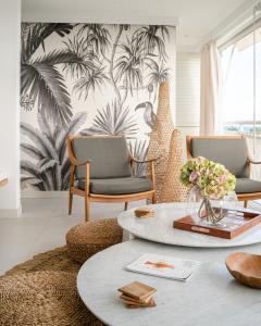 Appartement Toucan - Grand standing pleine vue mer في سانت فرانسوا: غرفة معيشة مع كرسيين وطاولة
