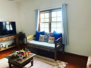 a living room with a couch and a window at Casa Recanto dos Encantos! in Tiradentes