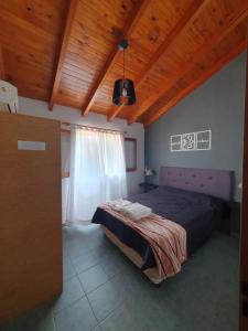 1 dormitorio con cama y techo de madera en Cabañas Andaluhe en Villa Carlos Paz