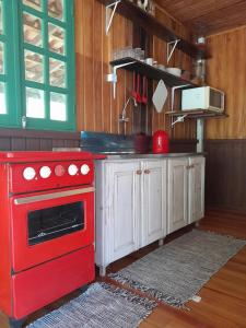 a kitchen with a red stove in a room at Morada Vale das Águas in São Bonifácio