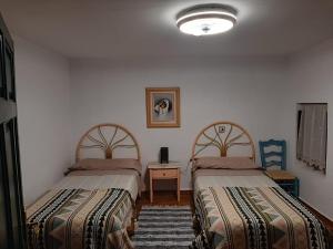 a bedroom with two beds and a table and a lamp at Casa Rural El Chacho - Velefique in Velefique