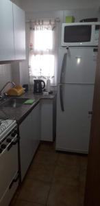 La cuisine est équipée d'un réfrigérateur blanc et d'un four micro-ondes. dans l'établissement Horizontal, à Mar del Plata