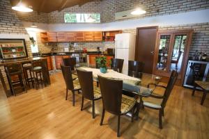 una sala da pranzo con tavolo e sedie di Casa de Campo, Refúgio do Lago a Itajaí