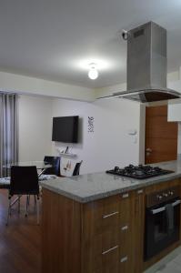 a kitchen with a stove and a counter top at Hermoso departamento en exclusivo Condominio in Arequipa