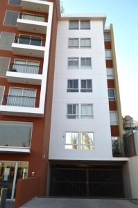 a tall white building with a garage in front of it at Hermoso departamento en exclusivo Condominio in Arequipa