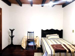 1 dormitorio con 1 cama, 1 mesa y 1 silla en Casa Lupita, en San Cristóbal de Las Casas
