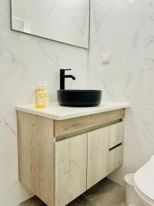 ein Badezimmer mit einem schwarzen Waschbecken auf einem hölzernen Waschtisch in der Unterkunft Apartamento Maria Fernanda, in the Centre of Luz in Luz