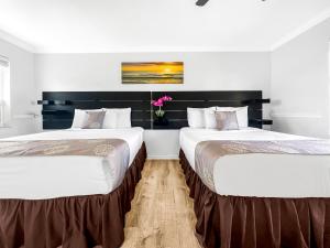 duas camas sentadas uma ao lado da outra num quarto em Hollywood Beach Seaside em Hollywood