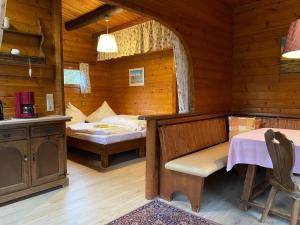 ein Schlafzimmer in einem Blockhaus mit einem Bett und einem Tisch in der Unterkunft Cozy holiday home on a horse farm in the Lüneburg Heath in Eschede