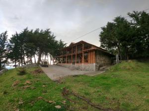 a house sitting on top of a grassy hill at RESERVA ANDINA in Piedecuesta