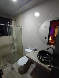 uma casa de banho com um WC e uma cabina de duche em vidro. em Vymar and Loto Azul em Pasto