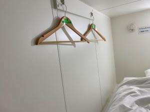 um quarto com dois cabides de madeira numa parede em Capsule in Kasakake MALE ONLY - Vacation STAY 72924v em Midori