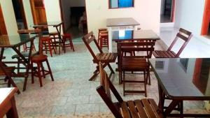 a group of tables and chairs in a room at Pousada da Adélia in Itaúnas