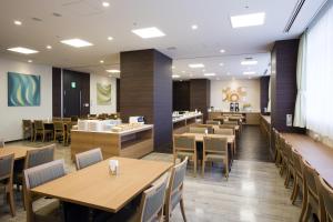 a dining room with wooden tables and chairs at Hotel Sunroute Chiba in Chiba