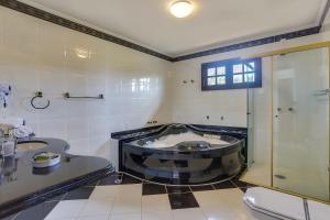 a bathroom with a shower and a sink and a toilet at Villa Boréal Hostellerie Pousada Boutique in Águas de Lindoia