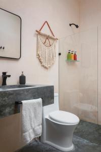 a bathroom with a white toilet and a shower at Rodina Boutique Hotel in Playa del Carmen